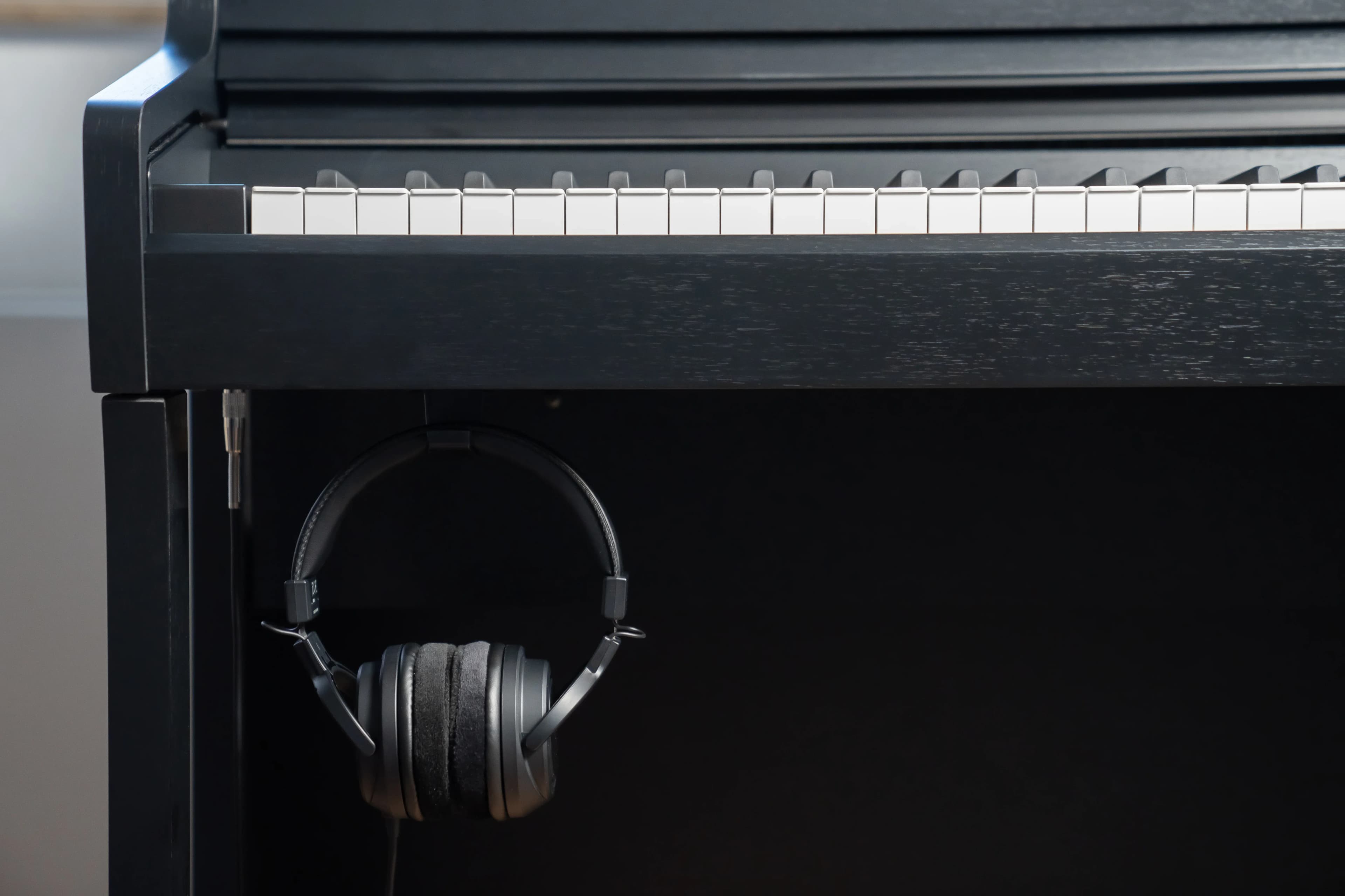Kawai SH-9 headphones hanging beneath a Kawai CA Series digital piano